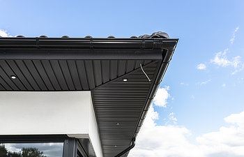 a modern graphite herringbone roof lining is attached to the trusses